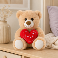 Peluche ours beige clair au cœur rouge Love posée sur une commode en bois clair