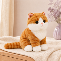 Chat en peluche orange tigré posé dans un intérieur clair