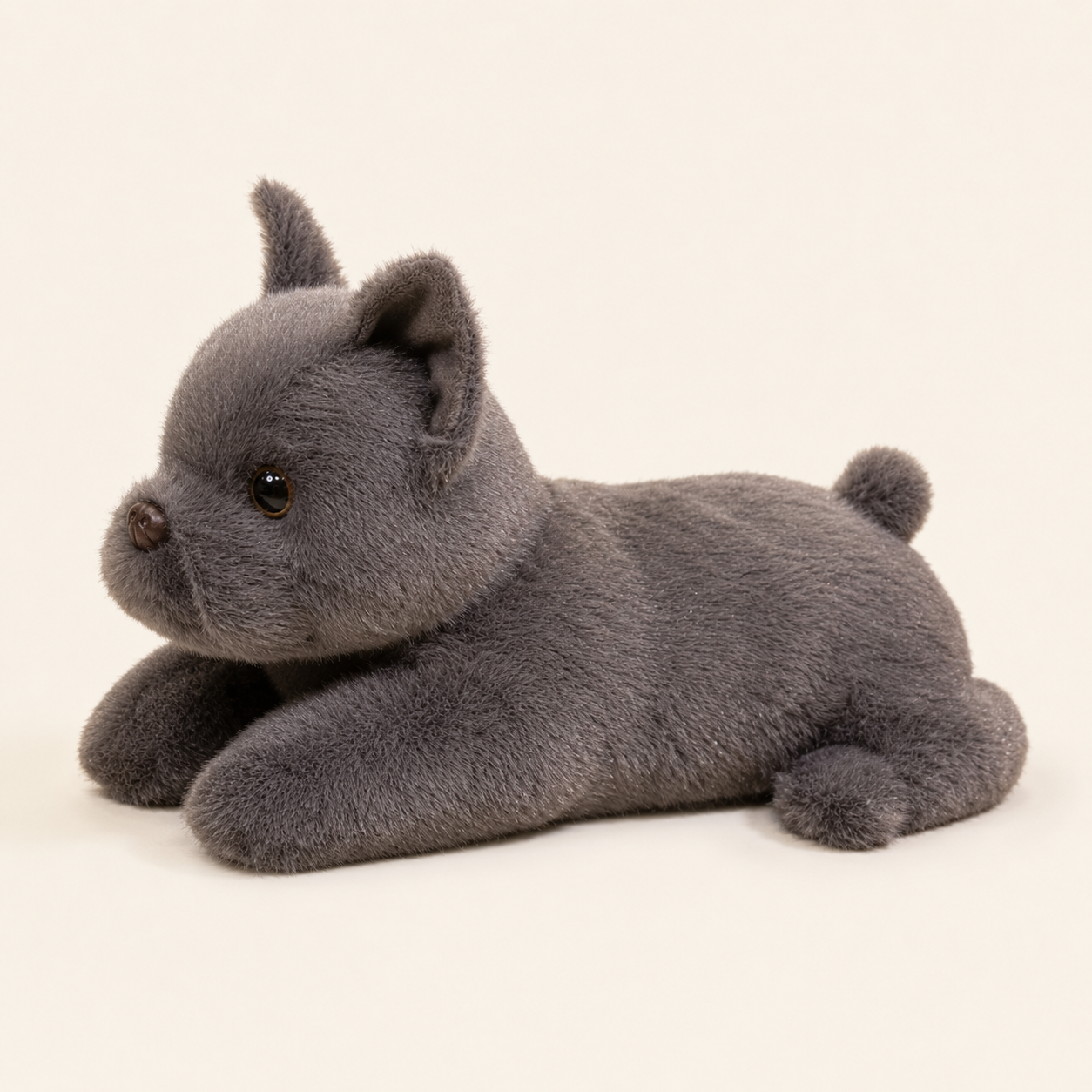 Peluche bouledogue gris couchée, vue latérale sur fond ivoire