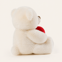 Peluche ourson blanche tenant un cœur rouge, vue arrière trois-quarts sur fond ivoire