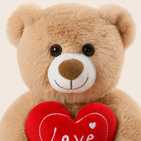 Gros plan sur le visage, la fourrure et le cœur rouge de la peluche ours beige clair