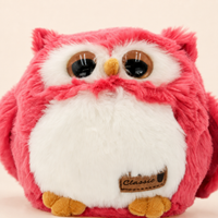 Gros plan sur le visage les yeux et la fourrure de la peluche hibou framboise