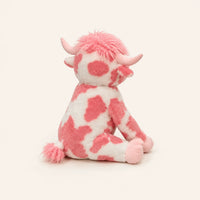 Peluche vache Highland rose vue de trois-quarts, fond ivoire