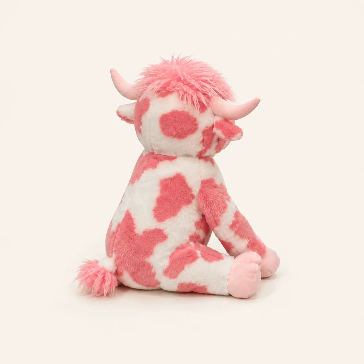 Peluche vache Highland rose vue de trois-quarts, fond ivoire