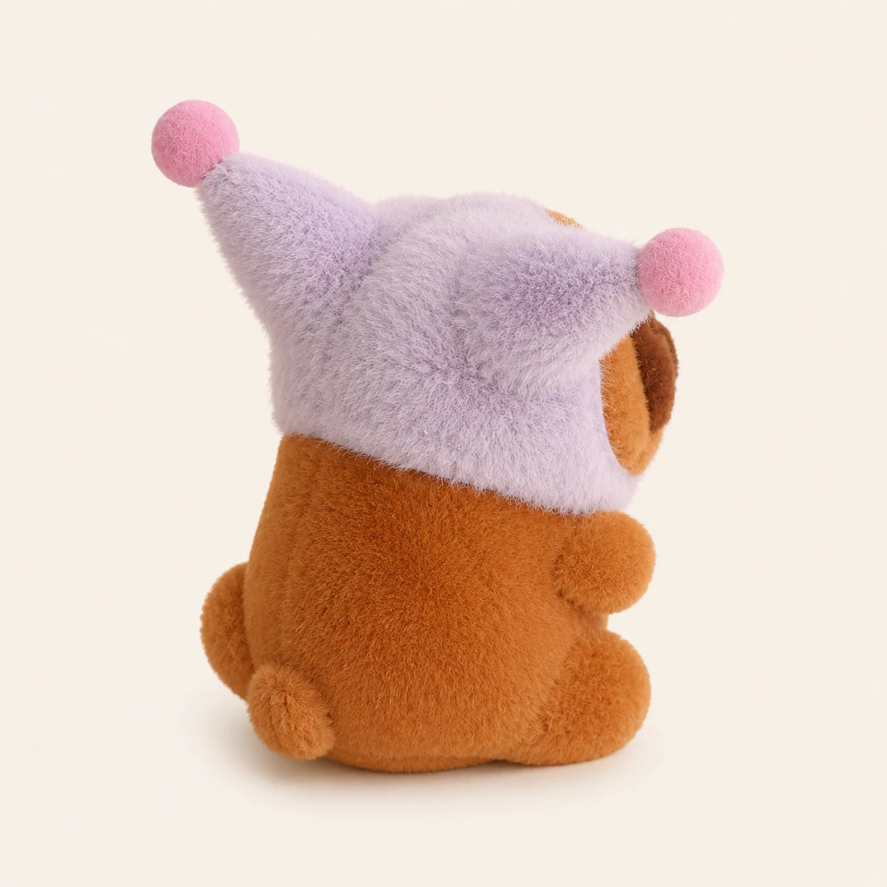 Peluche capybara au bonnet violet vue de cote, fond ivoire