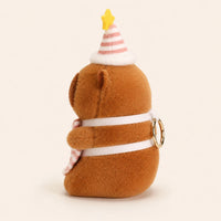 Peluche capybara au chapeau de fete vue de dos, fond ivoire