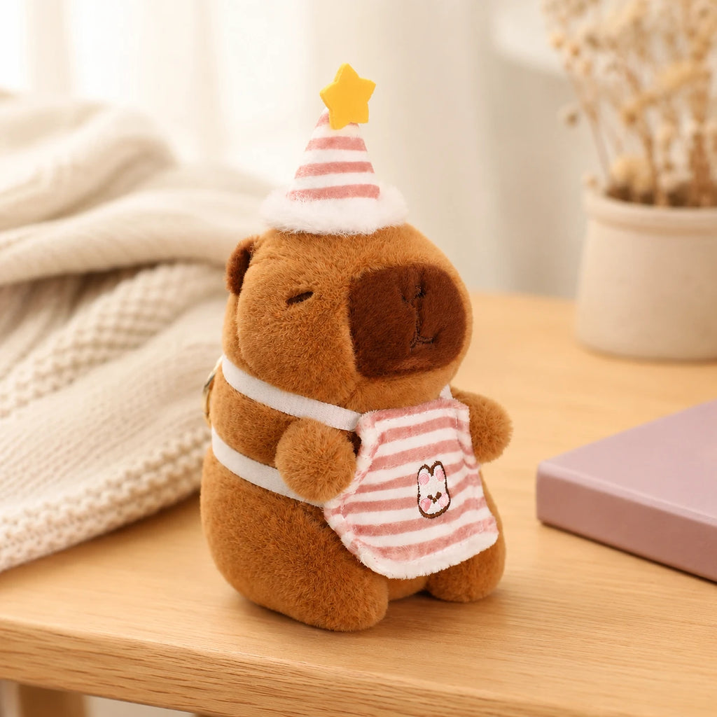 Peluche capybara au chapeau de fete posee sur une table, mise en situation