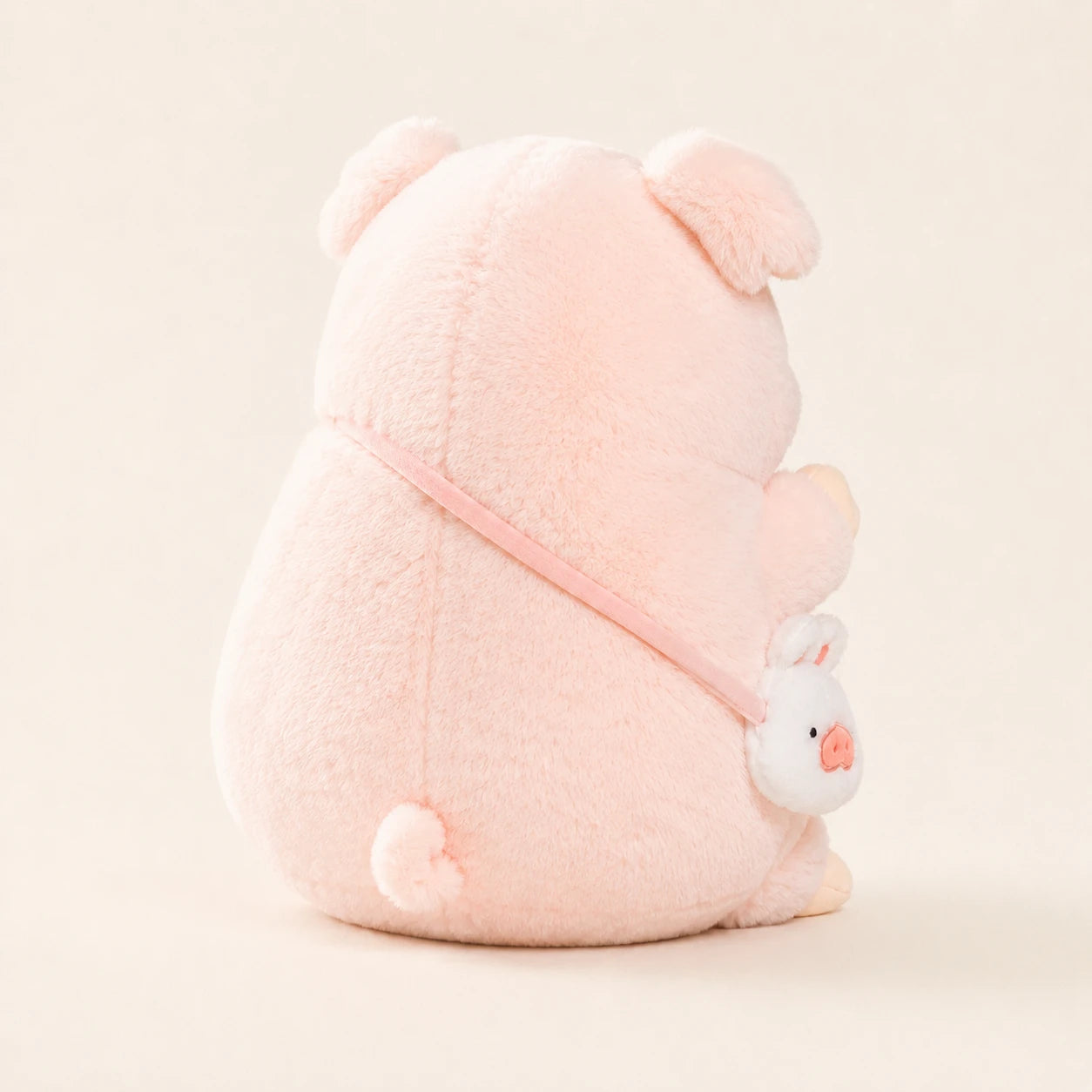 Peluche cochon rose vue de dos, fond ivoire