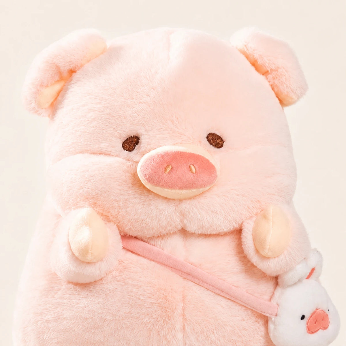 Gros plan visage peluche cochon rose, fond ivoire
