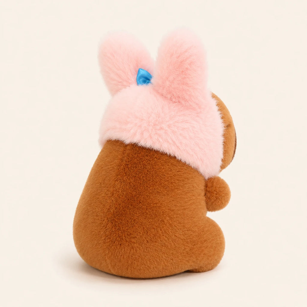 Peluche capybara bonnet lapin vue de cote, environ 12 cm, fond ivoire