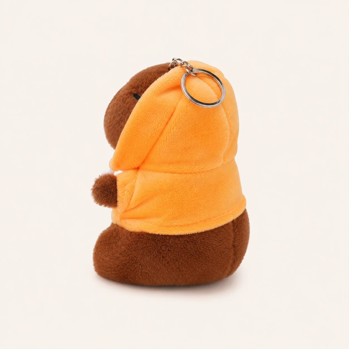 Peluche capybara porte-cles vue de cote, environ 12 cm, fond ivoire