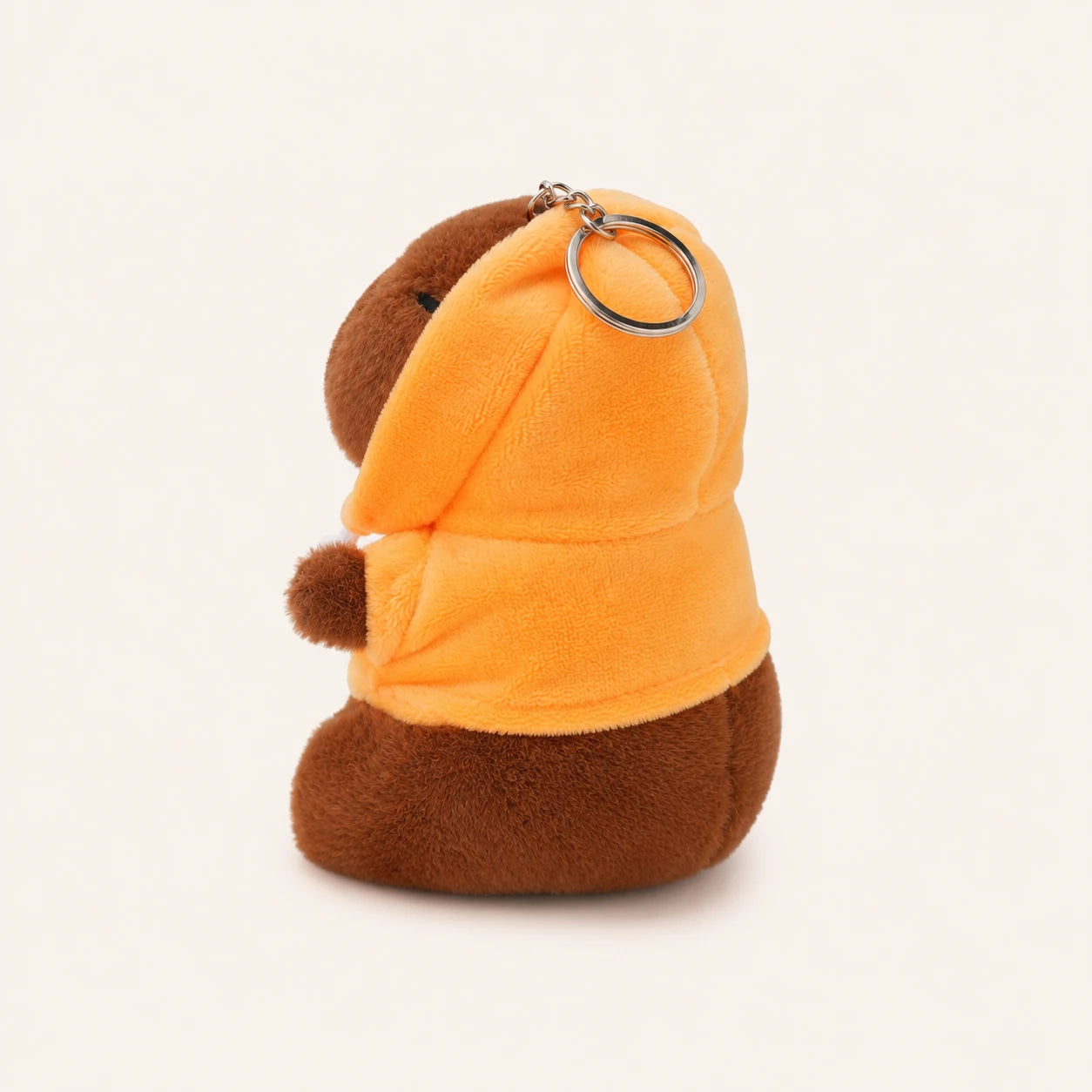 Peluche capybara porte-cles vue de cote, environ 12 cm, fond ivoire