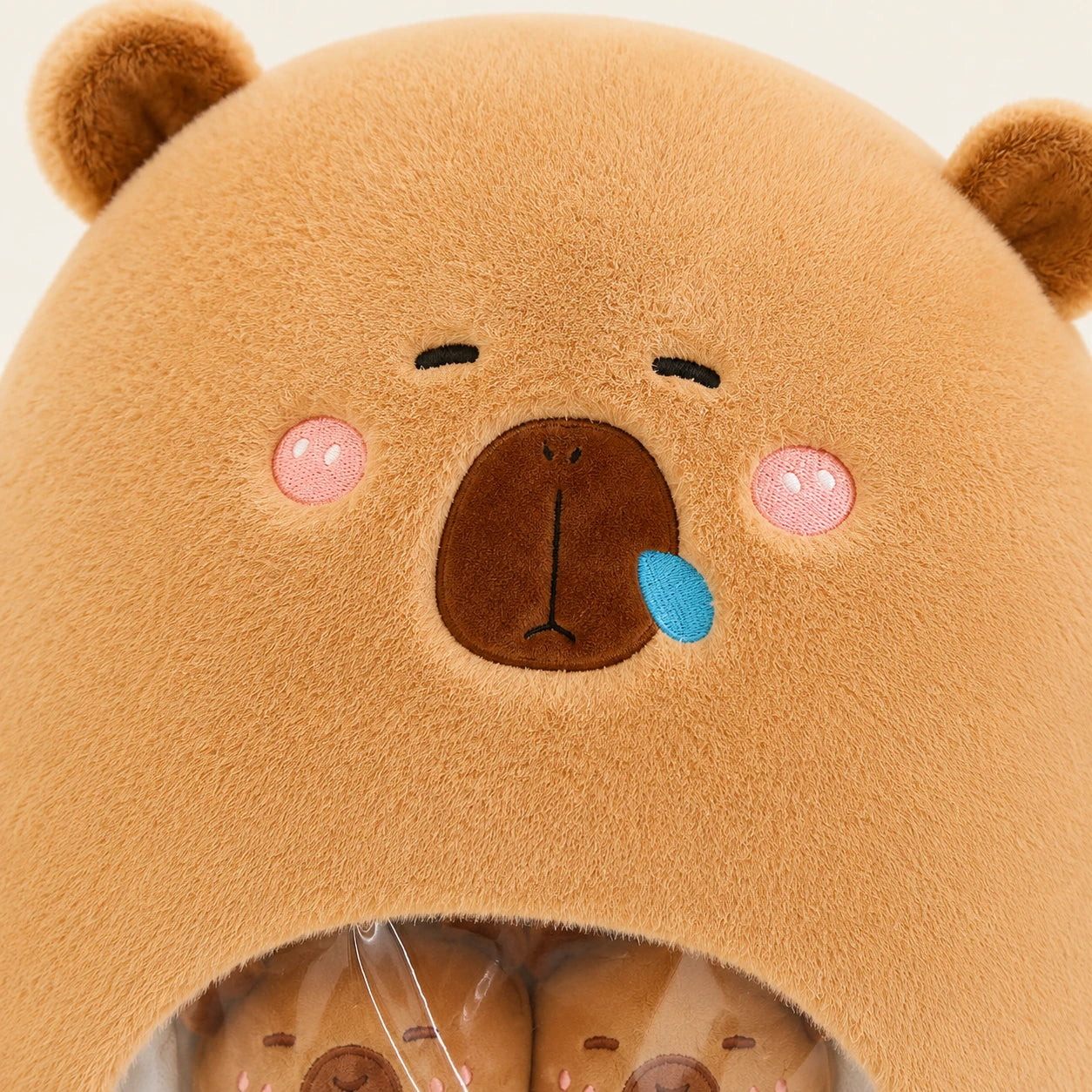 Gros plan visage sac peluche capybara, fond ivoire