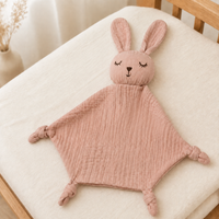 Doudou personnalisé lapin rose poudré dans une chambre de bébé chaleureuse
