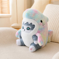 Peluche chat requin arc-en-ciel posée sur un canapé, mise en situation