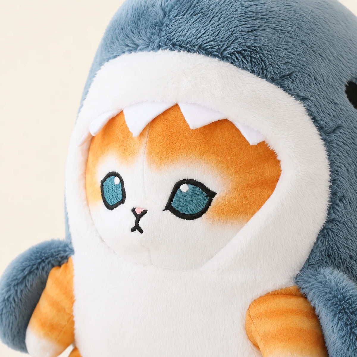Peluche chat requin bleu, gros plan sur le visage du chaton