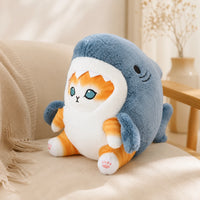 Peluche chat requin bleu posée sur un canapé, mise en situation