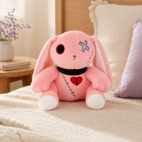 Peluche lapin gothique rose posée sur un lit - mise en situation