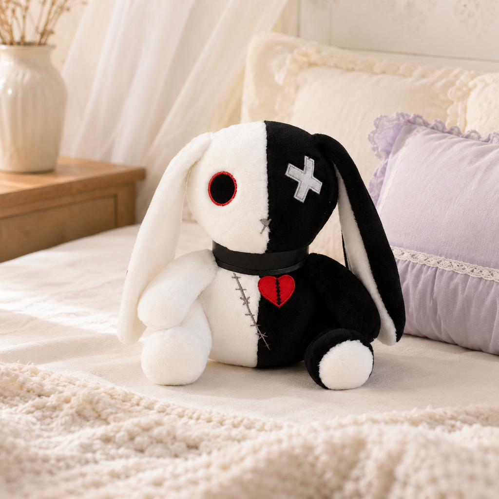 Peluche lapin gothique blanc et noir posée sur un lit - mise en situation
