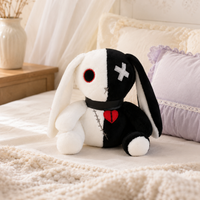 Peluche lapin gothique blanc et noir posée sur un lit - mise en situation