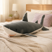 Grande peluche requin gris à taille réelle sur un lit
