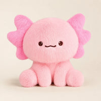 Peluche axolotl rose vue de face, assise, fond ivoire