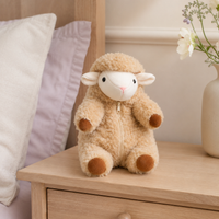 Peluche mouton agneau posée sur une table de chevet, ambiance chambre douce