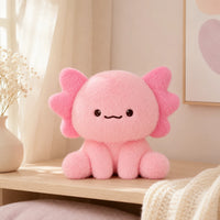 Peluche axolotl rose posée sur une étagère dans une chambre douce