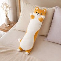 Coussin peluche Shiba Inu posé sur un lit