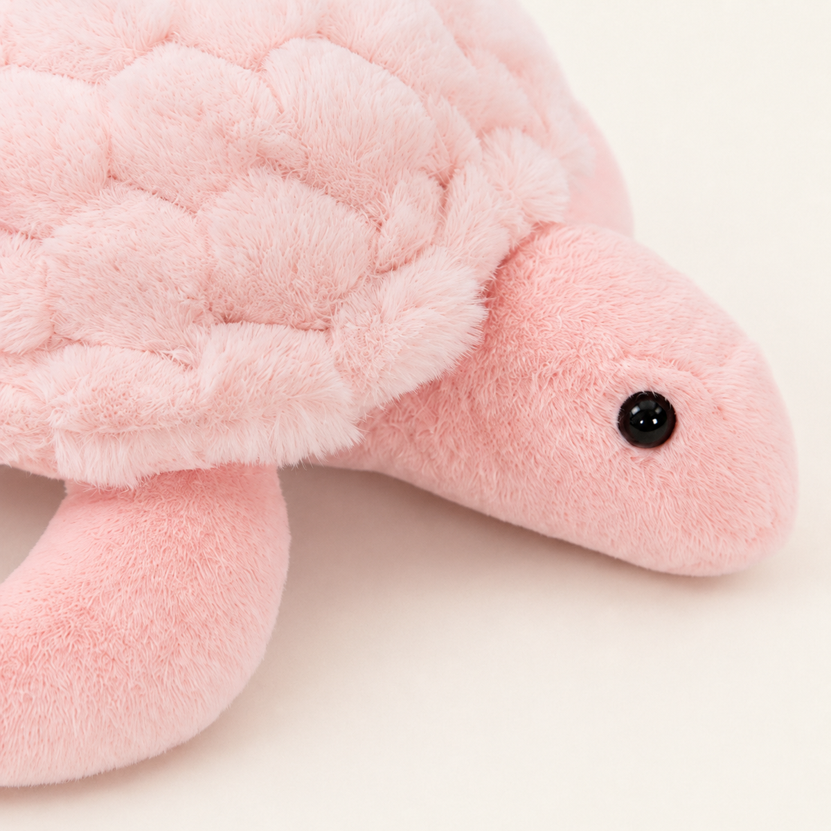 Peluche tortue rose, gros plan sur la tête et la carapace texturée