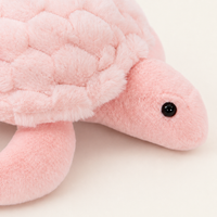 Peluche tortue rose, gros plan sur la tête et la carapace texturée