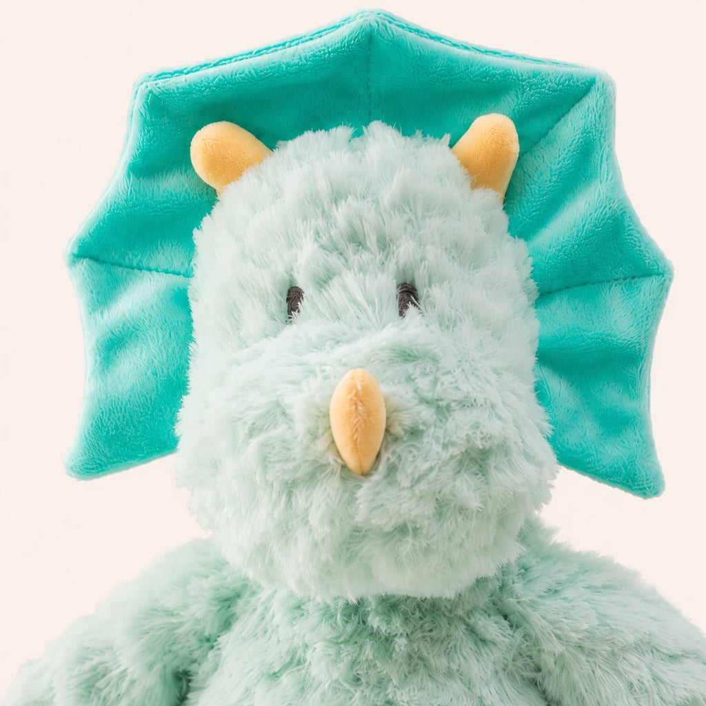 Gros plan sur le visage et la texture douce de la peluche dinosaure