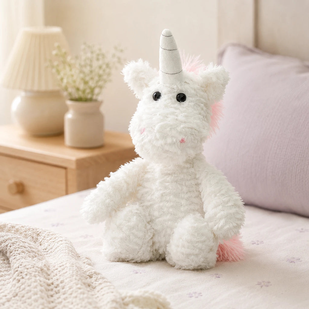 Peluche licorne posée sur un lit douillet dans une chambre chaleureuse