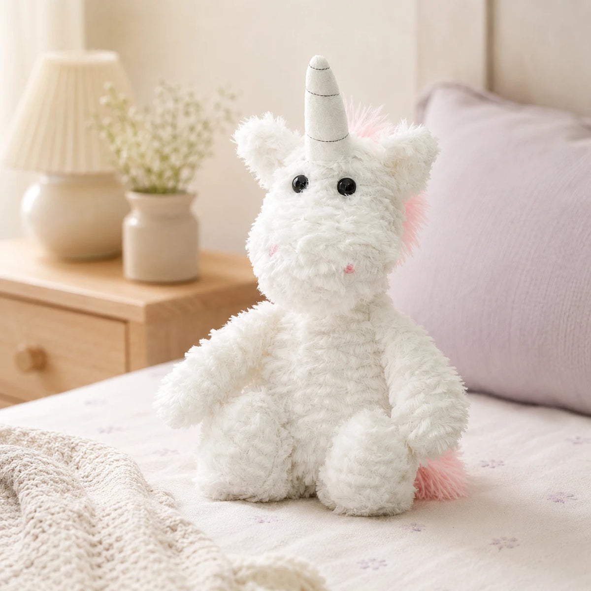 Peluche licorne posée sur un lit douillet dans une chambre chaleureuse