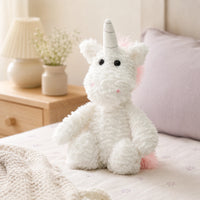 Peluche licorne posée sur un lit douillet dans une chambre chaleureuse