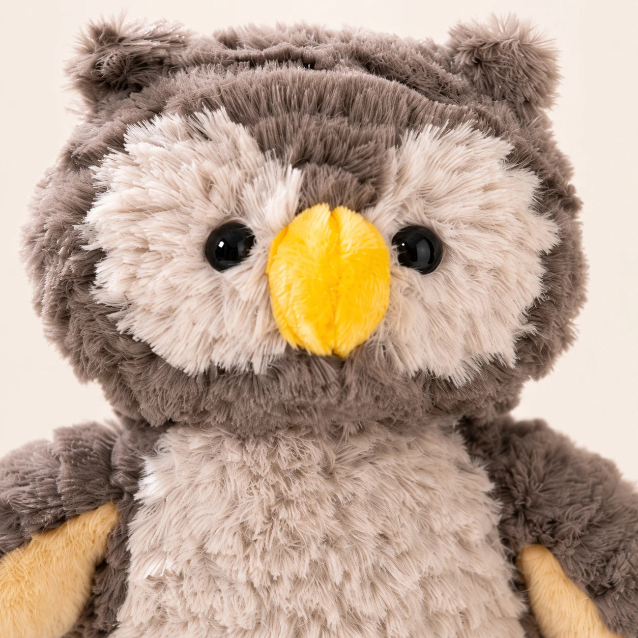 Gros plan sur le visage et le bec jaune de la peluche hibou