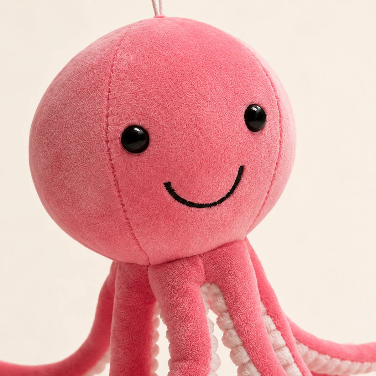 Gros plan sur le visage souriant de la peluche pieuvre rose
