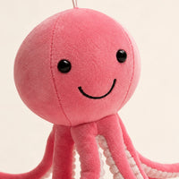 Gros plan sur le visage souriant de la peluche pieuvre rose