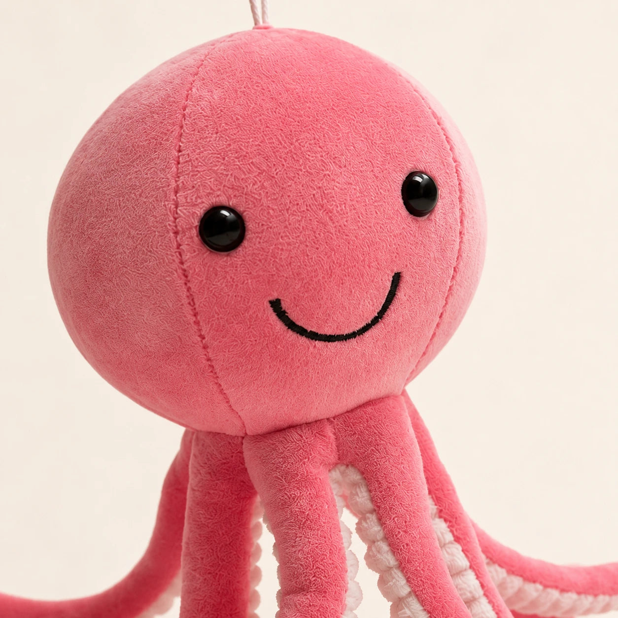 Gros plan sur le visage souriant de la peluche pieuvre rose