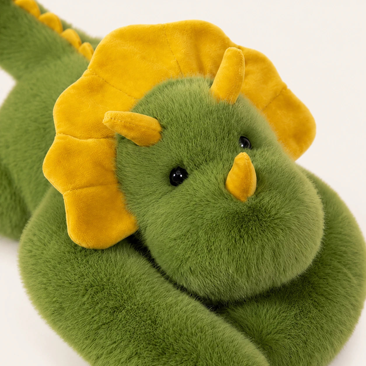 Peluche triceratops verte, gros plan détail texture et coutures