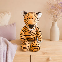 Peluche tigre rayé posée sur une commode dans une chambre douce