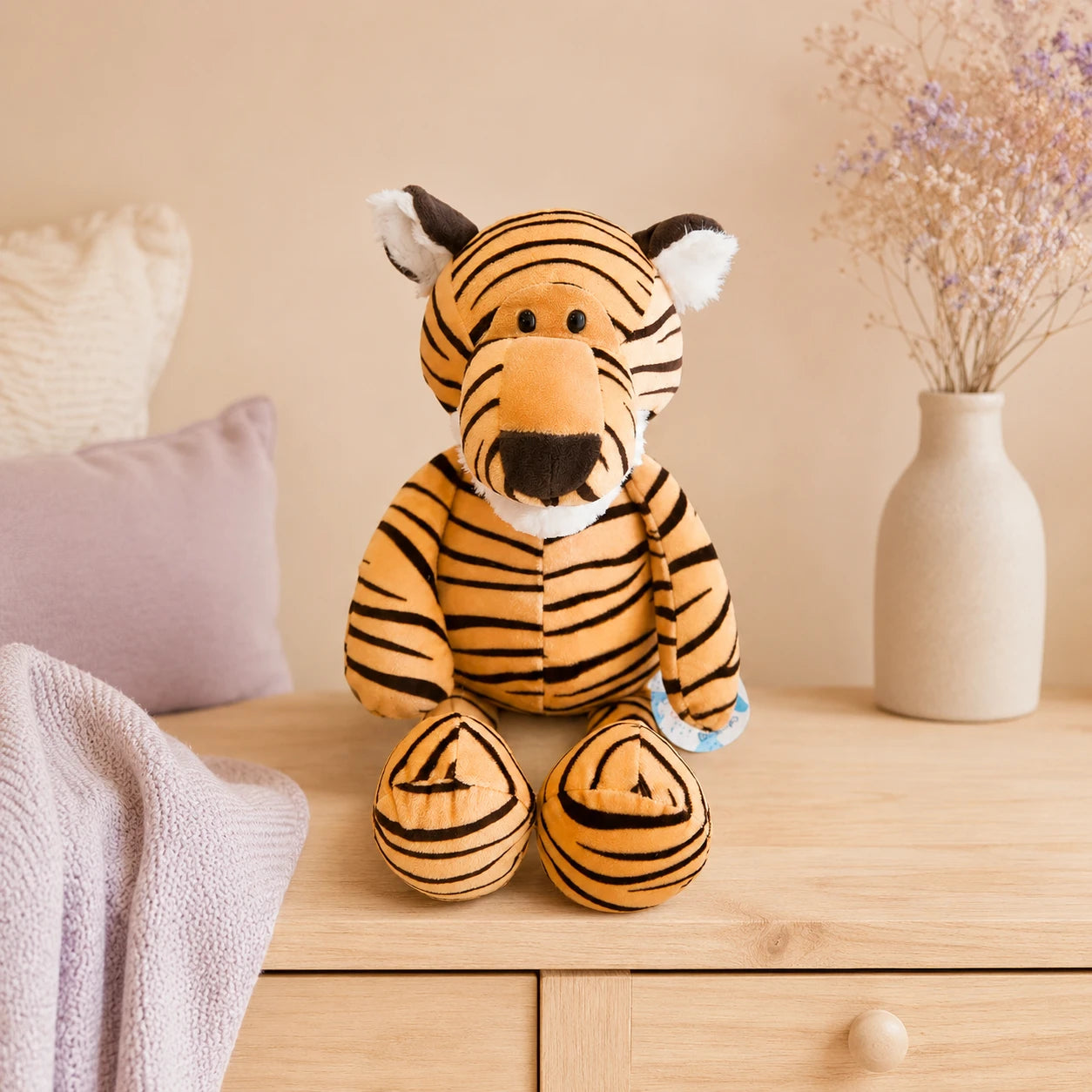 Peluche tigre rayé posée sur une commode dans une chambre douce