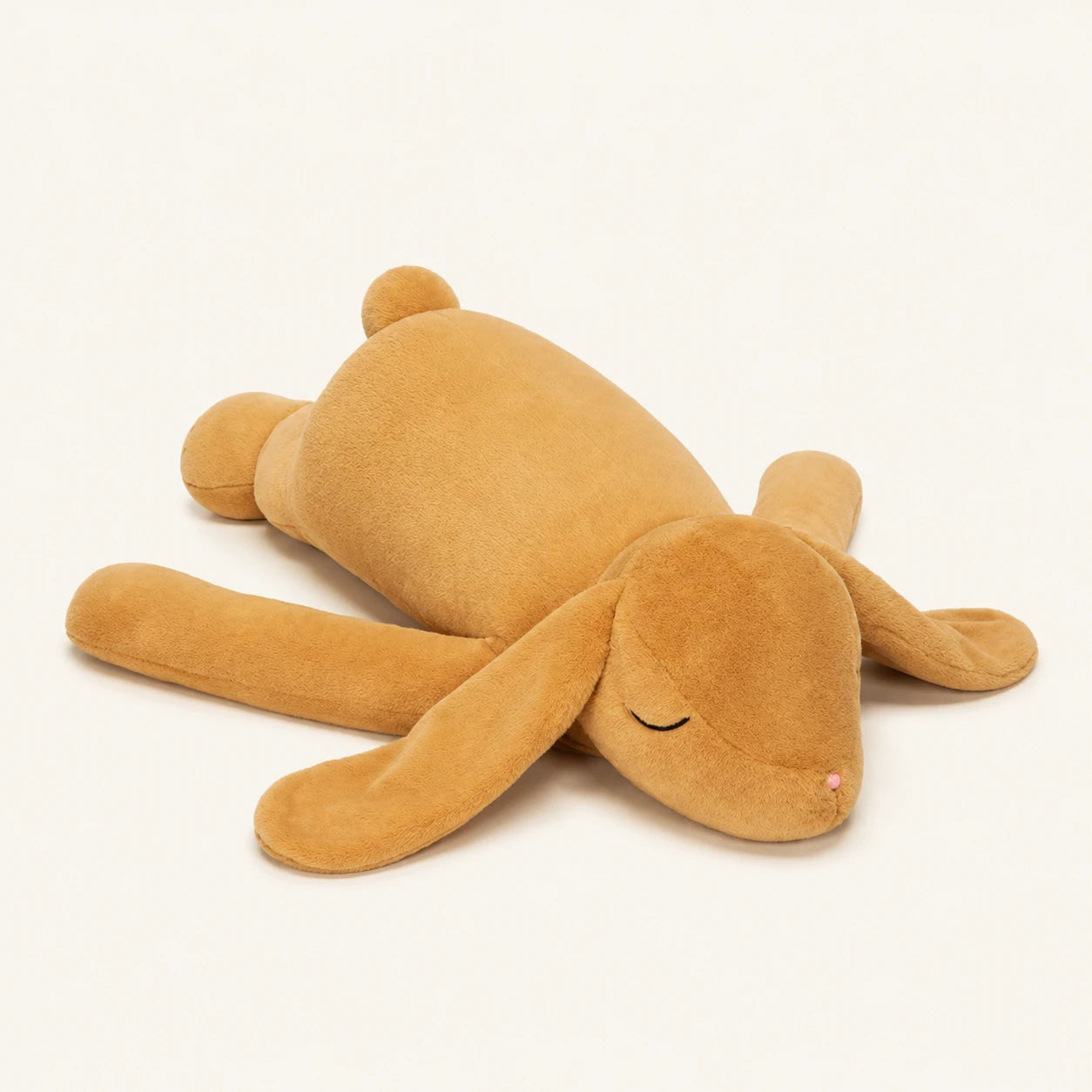 Grande peluche lapin couche beige, corps entier, fond ivoire