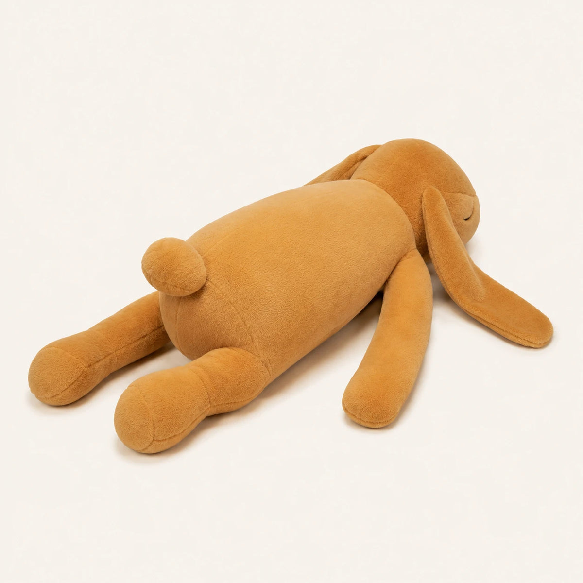 Peluche lapin beige vue de cote, longues oreilles, fond ivoire