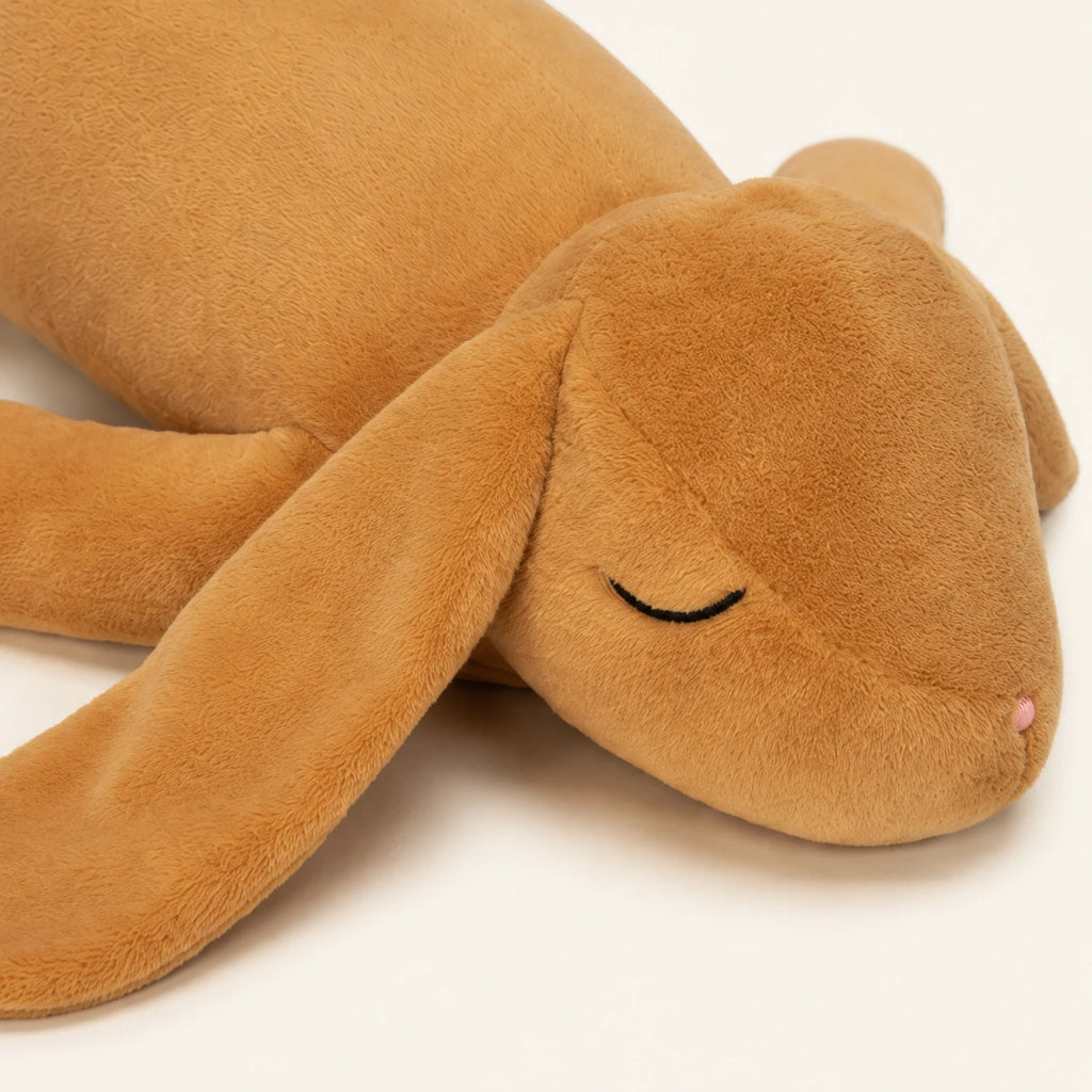 Gros plan visage peluche lapin beige, texture douce