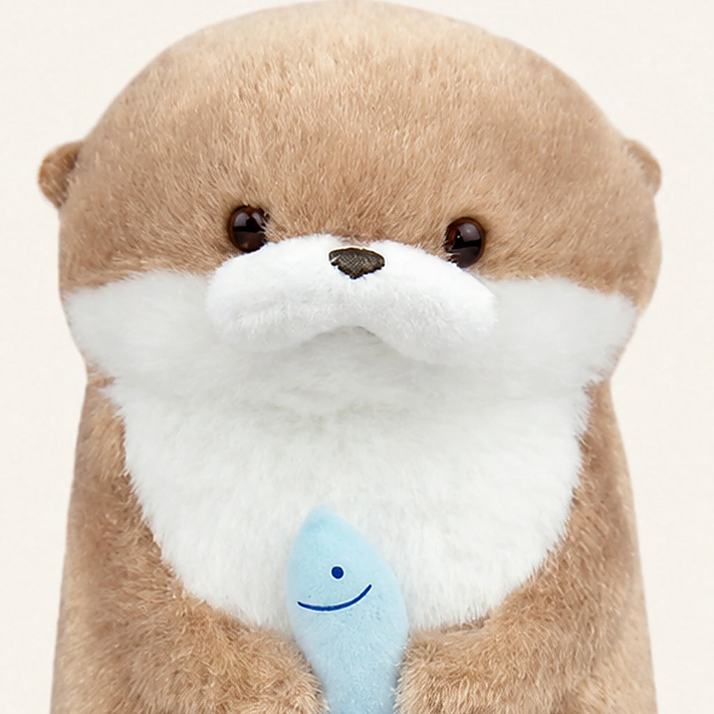 Détail visage et poisson du porte-clé peluche loutre kawaii