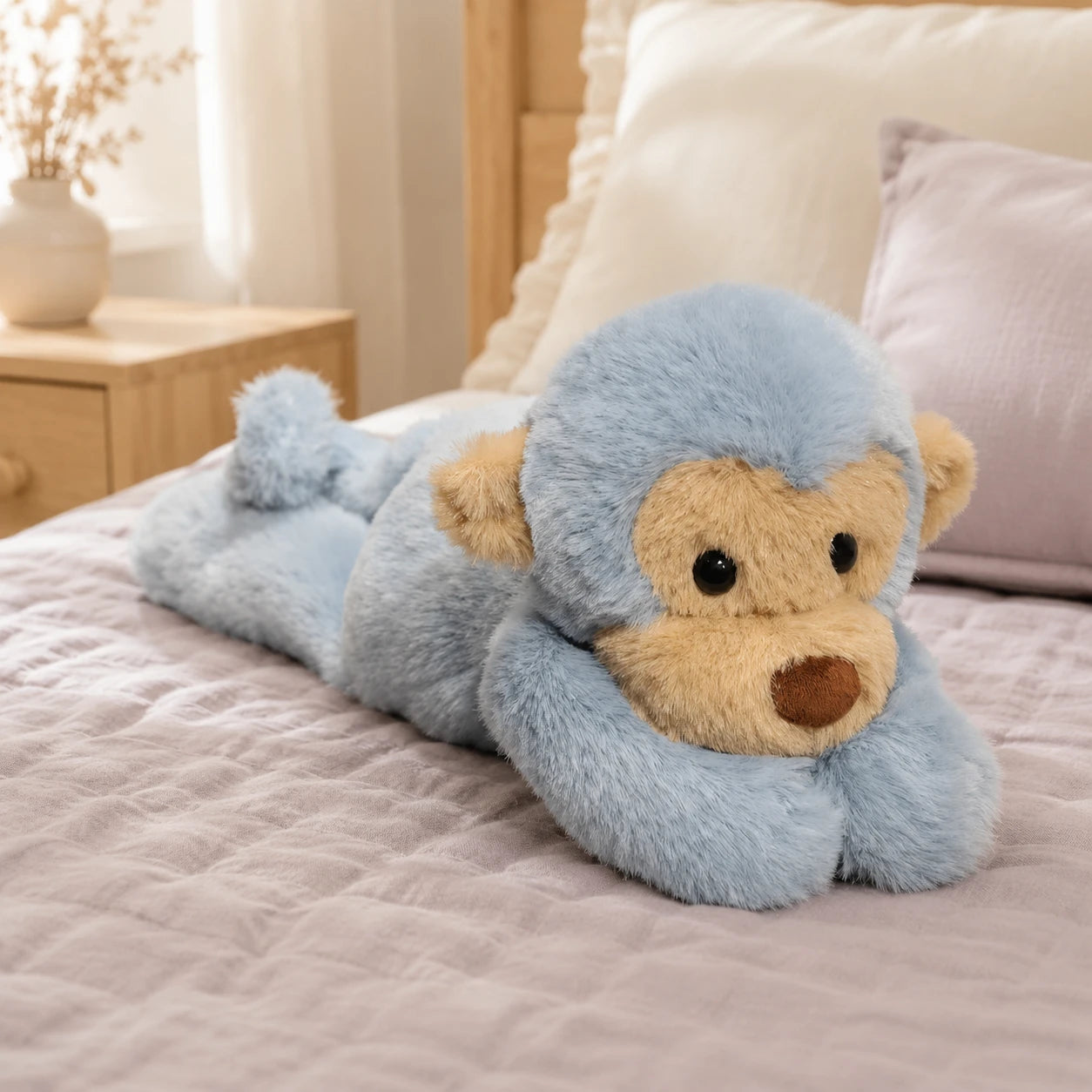 Peluche singe bleue posee sur un lit douillet dans une chambre cosy