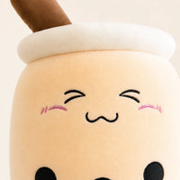Gros plan sur le visage kawaii et la texture douce de la peluche boba beige