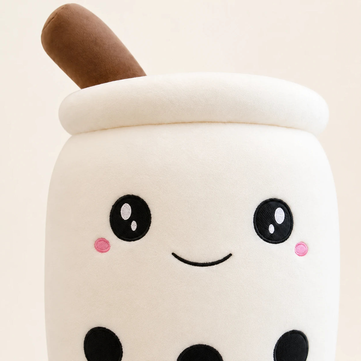 Gros plan sur le visage kawaii et la texture douce de la peluche boba blanche
