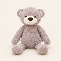 Ours en peluche gris-taupe assis, vue de face sur fond ivoire